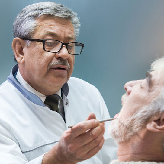 dentist is checking old guy mouth