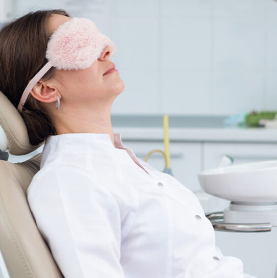 lady is wearing eyes mask and sleeping on dental chair